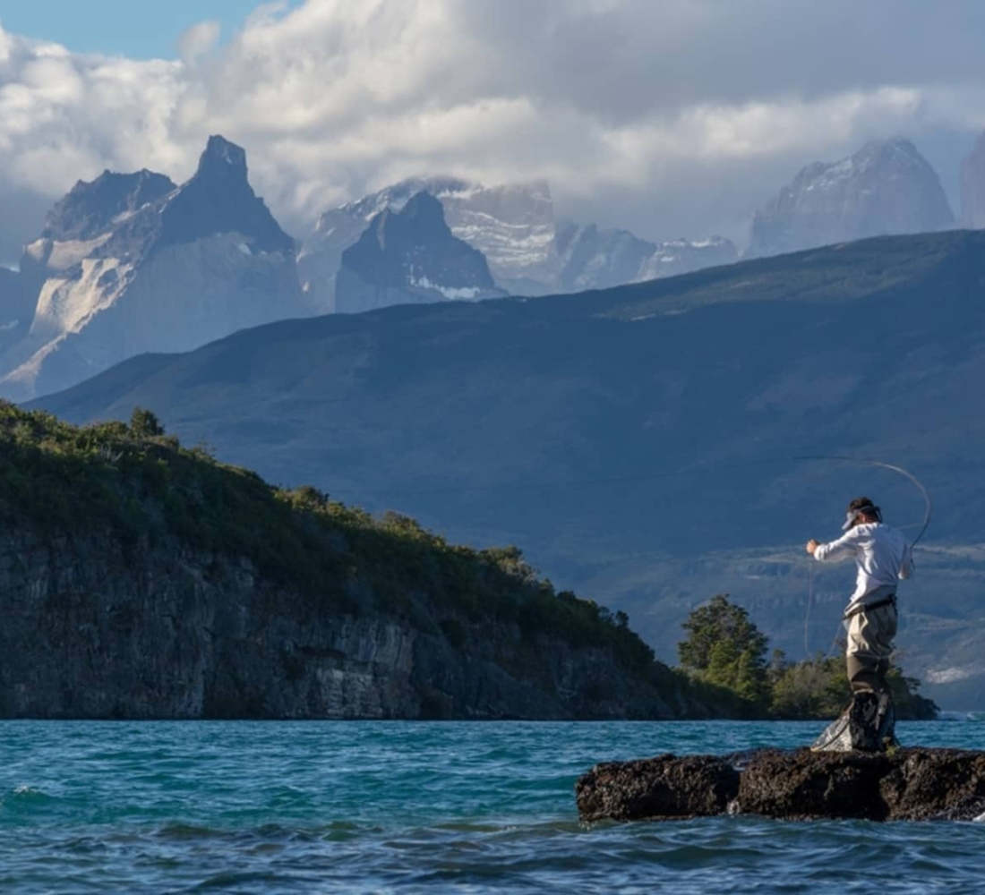 Person fishing on Lake Toro with Los Cuernos del Paine mountains in the background